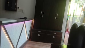 Una cucina moderna con mobili scuri, un piano di lavoro bianco e un forno a incasso.