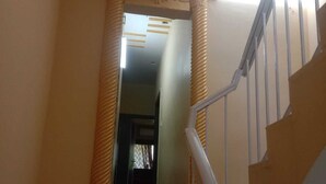 Una scala con corrimano e una porta che dà su un'altra stanza.