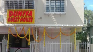 Un edificio di due piani con un cartello che riporta 'DUNIYA GUEST HOUSE'.