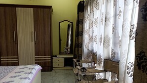 Ein Schlafzimmer mit Bett, Kleiderschrank, Spiegel, Schminktisch und Stuhl.