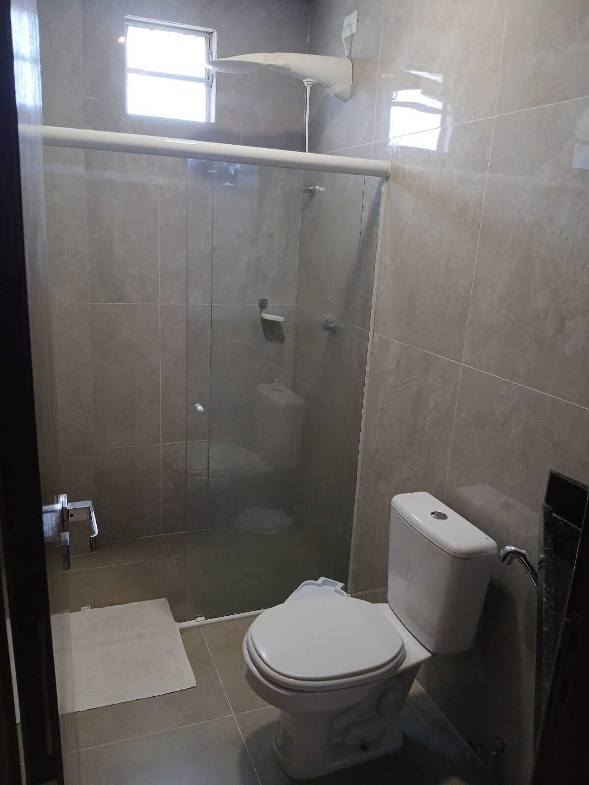 Un baño con ducha envuelta en vidrio, inodoro y bidé.