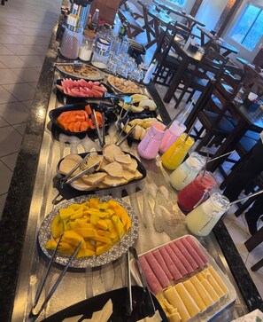 A buffet with various food items and drinks. - Hotel Prime Suítes (Cupira)