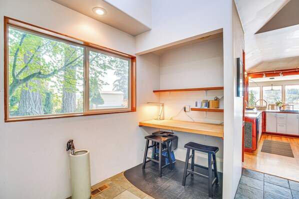 A modern kitchen with a large window, a sink, and two stools. - Gig Harbor Home: Large Deck, Outdoor Dining Area (Gig Harbor)