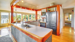 A modern kitchen with granite countertops, stainless steel appliances, and wooden accents. - Gig Harbor Home: Large Deck, Outdoor Dining Area (Gig Harbor)