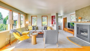 A modern living room with a sofa, armchairs, a coffee table, and a fireplace. - Gig Harbor Home: Large Deck, Outdoor Dining Area (Gig Harbor)