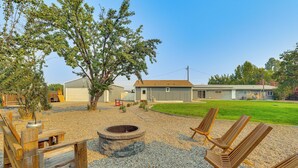A backyard with a fire pit, wooden chairs, and a lawn. - Modern Studio Near Lake Lowell: 6 Mi to Boat Ramp (Nampa)