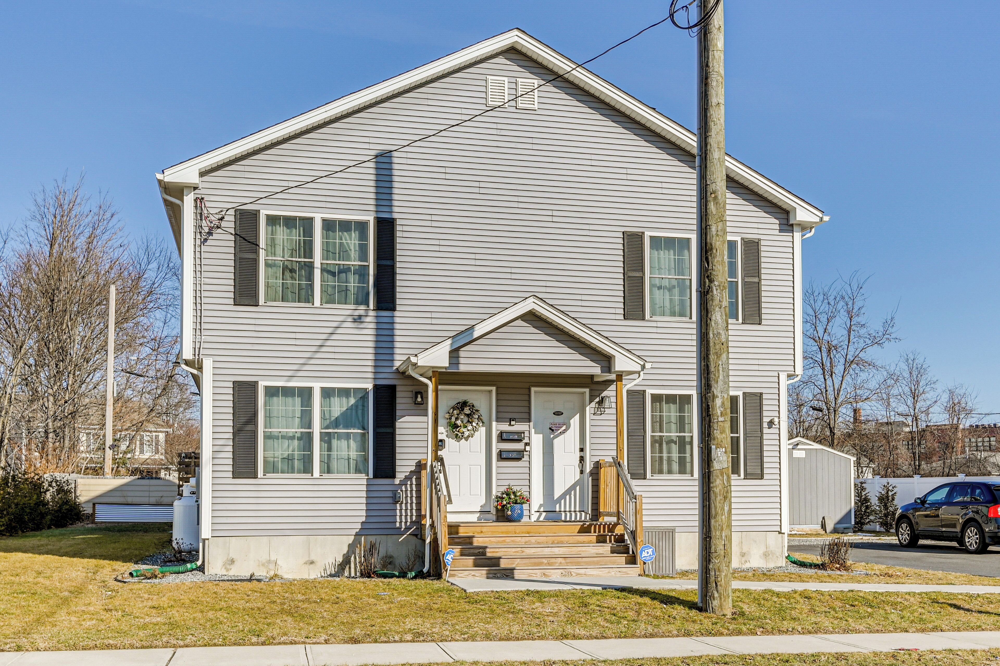 A two-story house with a front porch, a garage, and a driveway.
