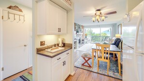 A modern kitchen with white cabinets, a granite countertop, and a dining area with a wooden table and chairs. - 1 Mi to Ski Lifts: Sugar Mountain Condo (Banner Elk)