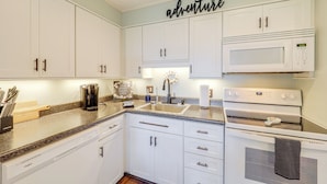 A kitchen with white cabinets, a microwave, and a sink. - 1 Mi to Ski Lifts: Sugar Mountain Condo (Banner Elk)