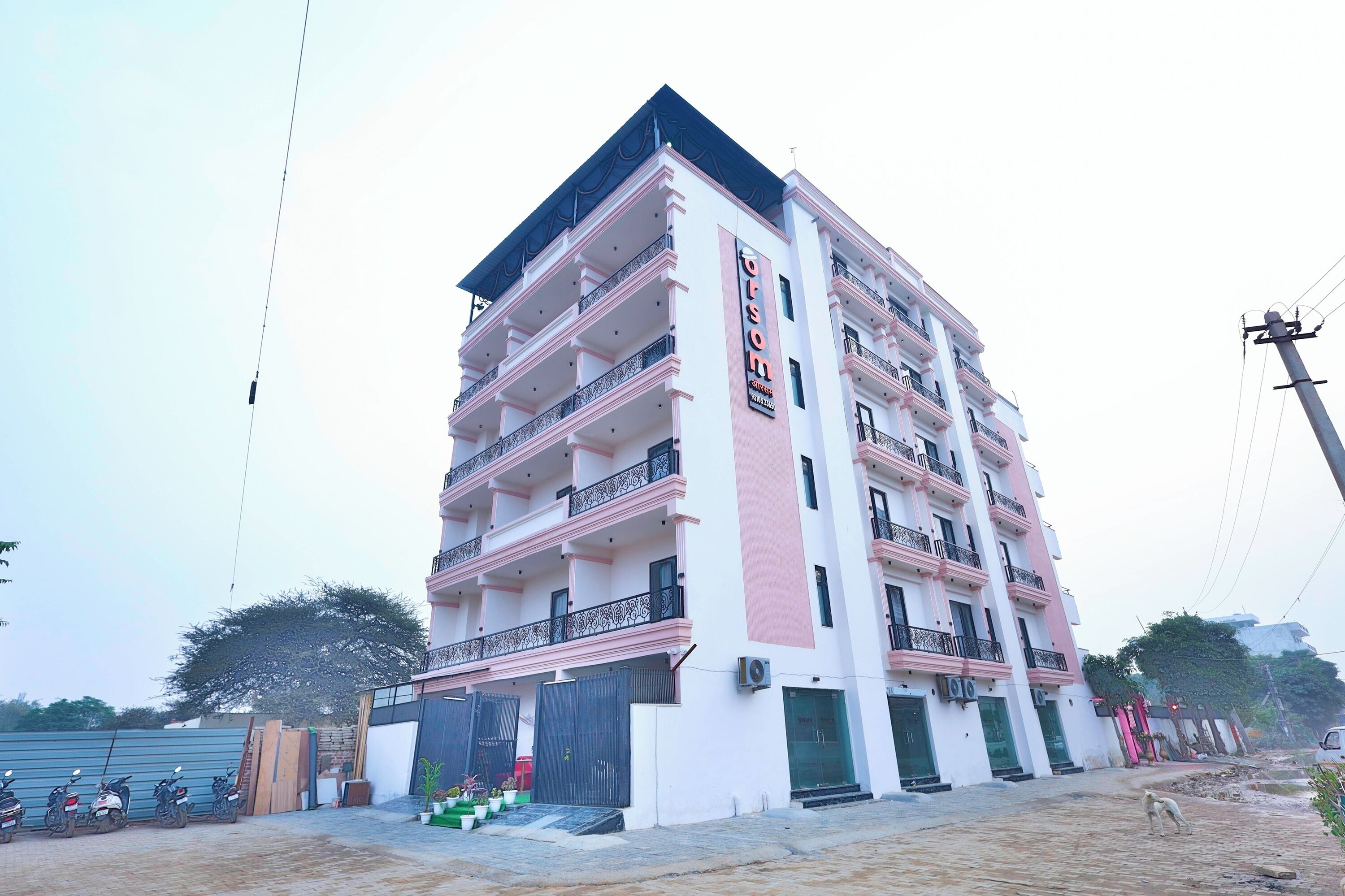 Un edificio de varios pisos con balcones, un letrero que dice 'OFSON' y una entrada con reja.