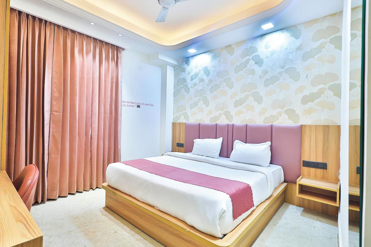 Une chambre d’hôtel moderne avec un grand lit, une tête de lit en bois et un banc intégré.