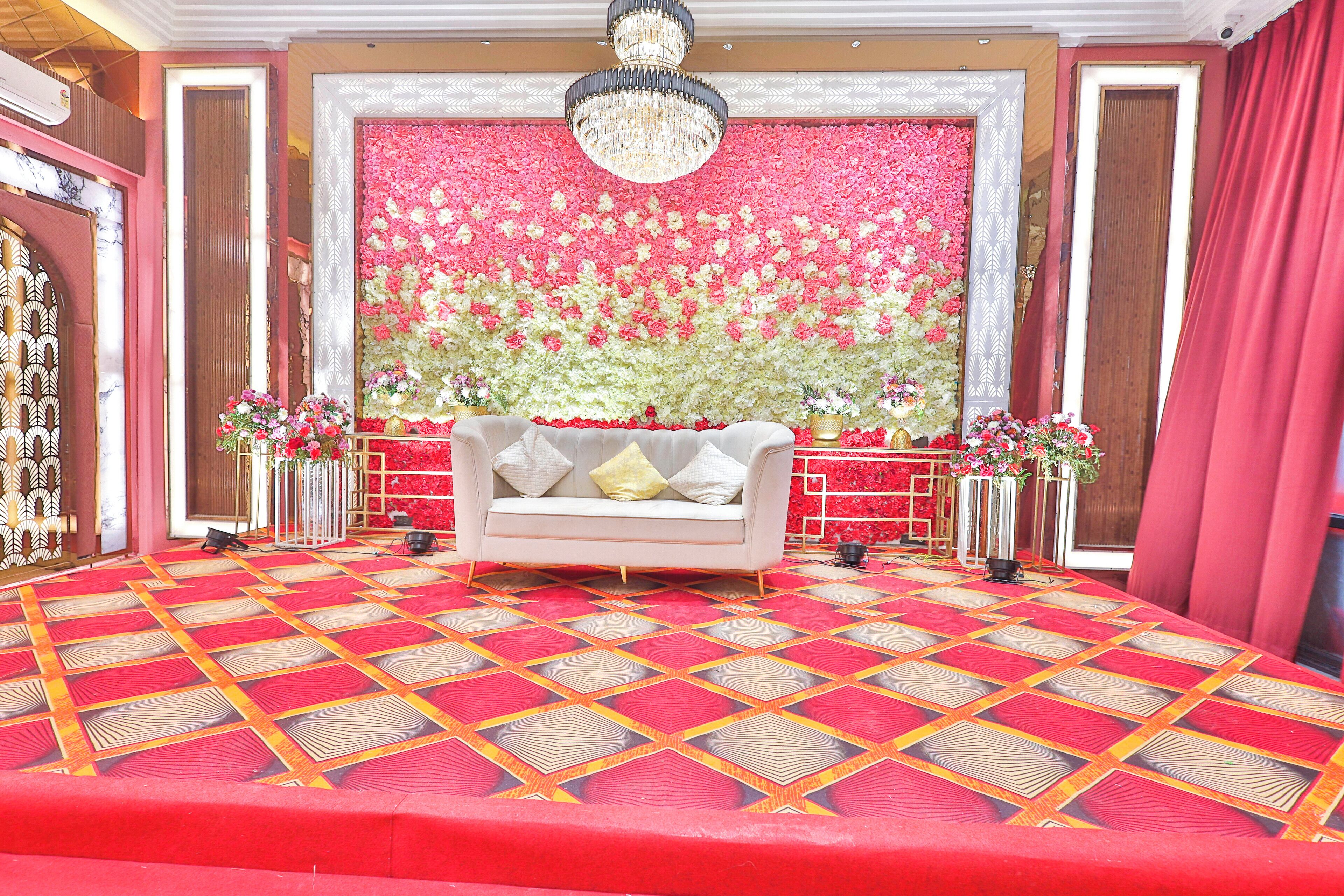 Una habitación con alfombra estampada, un sofá con cojines y un fondo floral.
