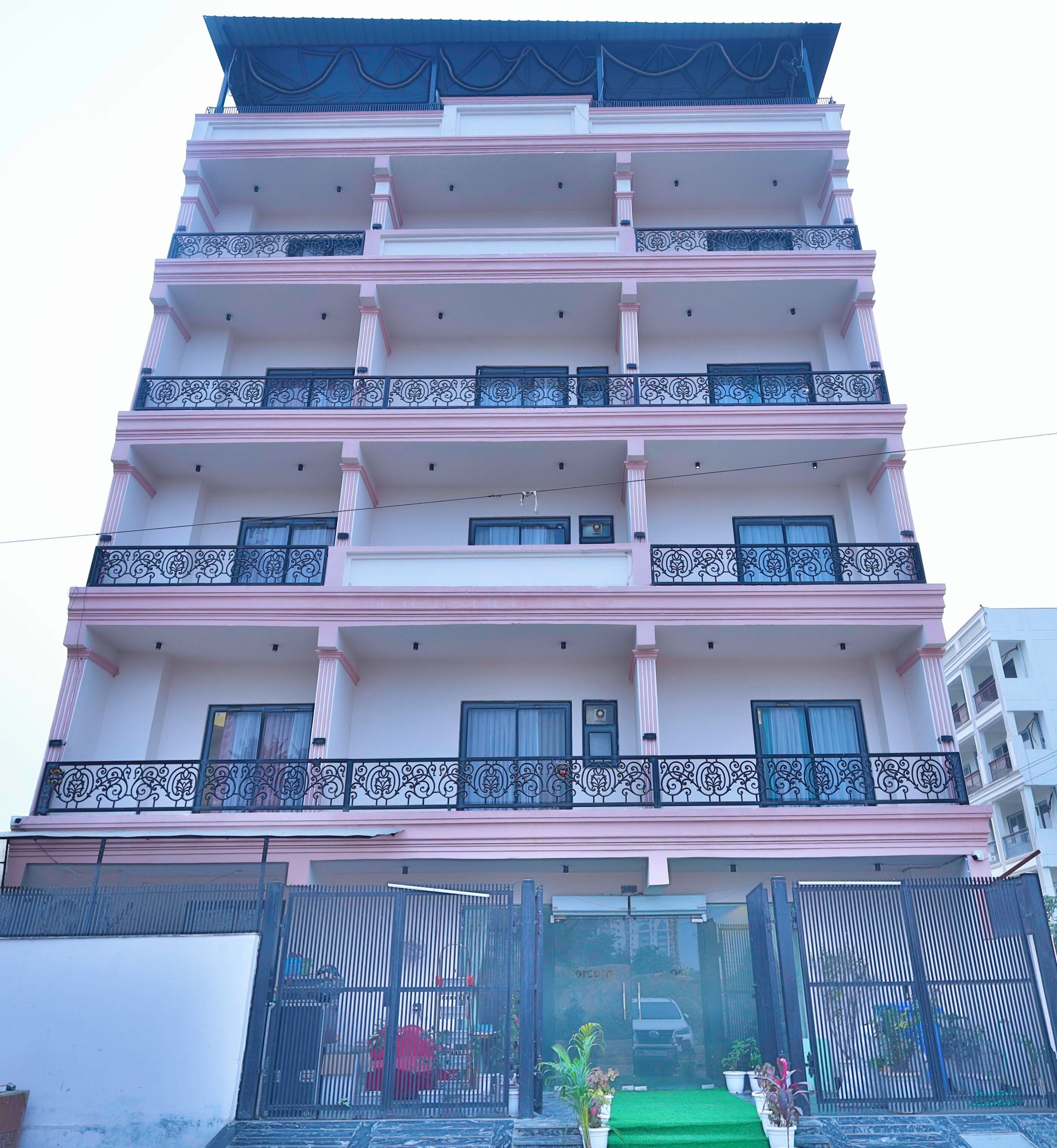 A multi-story building with balconies and a gated entrance.