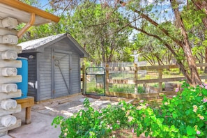 Situated in a lush garden, this cabin offers a serene natural setting with a variety of flowering plants and trees.