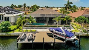 Une propriété située au bord de l’eau, dotée d’un quai, d’un bateau et d’une piscine.