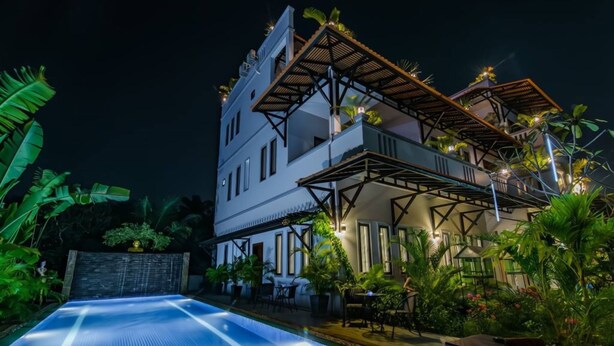 A multi-story building with a pool, outdoor seating, and tropical plants. - Angkor Lany Sinit Resort (Siem Reap)