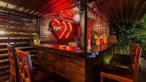 A bar area with wooden paneling, a heart-shaped neon sign, and bar stools. - Angkor Lany Sinit Resort (Siem Reap)