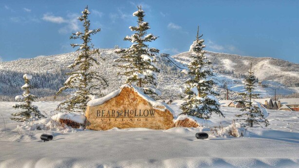 Paisaje nevado con un cartel que dice "BEAR HOLLOW VILLAGE".