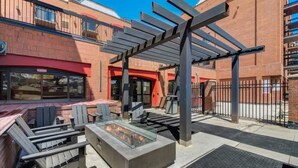 An outdoor seating area with Adirondack chairs and a fire feature. - Ski In Ski Out 2BR Condo with Hot Tub and Pool (Park City)