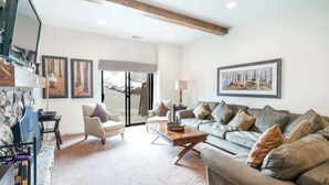 A living room with a sofa, armchairs, a coffee table, and artwork on the walls. - Ski In Ski Out 2BR Condo with Hot Tub and Pool (Park City)