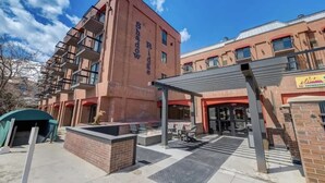 A building with a red facade, outdoor seating area, and a covered entrance. - Ski In Ski Out 2BR Condo with Hot Tub and Pool (Park City)