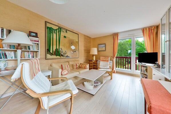 A living room with a sofa, chairs, a coffee table, a TV, and a bookshelf. - Crouesty Harbor, flat with a pool for 4 (Arzon)