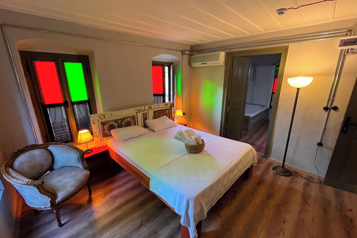 Ein Hotelzimmer mit Bett, Nachttisch, Stuhl und Lampe.