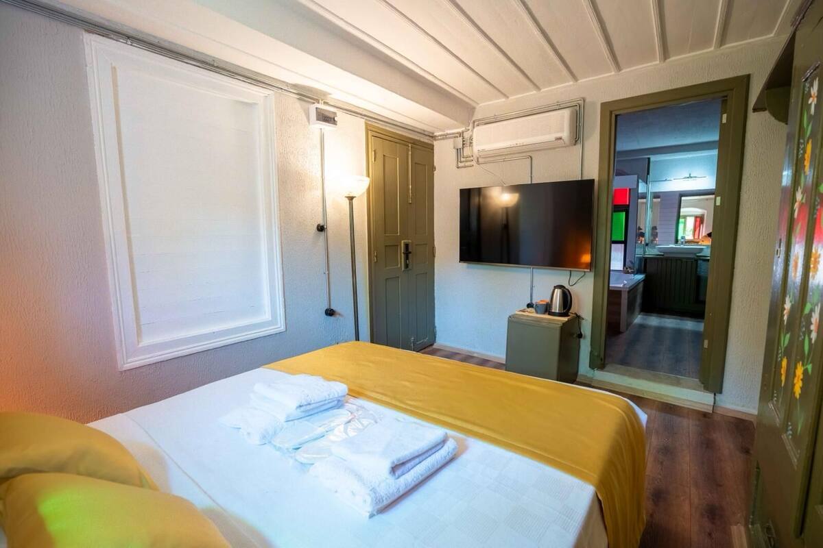 Ein Hotelzimmer mit Bett, Fernseher, einer kleinen Küchenzeile und einem durchgegangenen Tür erkennbaren Badezimmer.