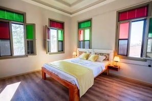 A bedroom with a bed, bedside tables, and windows with blinds. - Latibule Macaron Guest House (Ayvalik)
