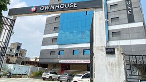 Ein Hotel namens OWNHOUSE mit modernem Design, das eine auffällige blaue Fassade und ein Schild über dem Eingang zeigt.