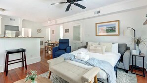 A bedroom with a bed, a chair, a desk, a ceiling fan, and a window. - The Magnolia on Bull, Modern | Charming | Central (Savannah)