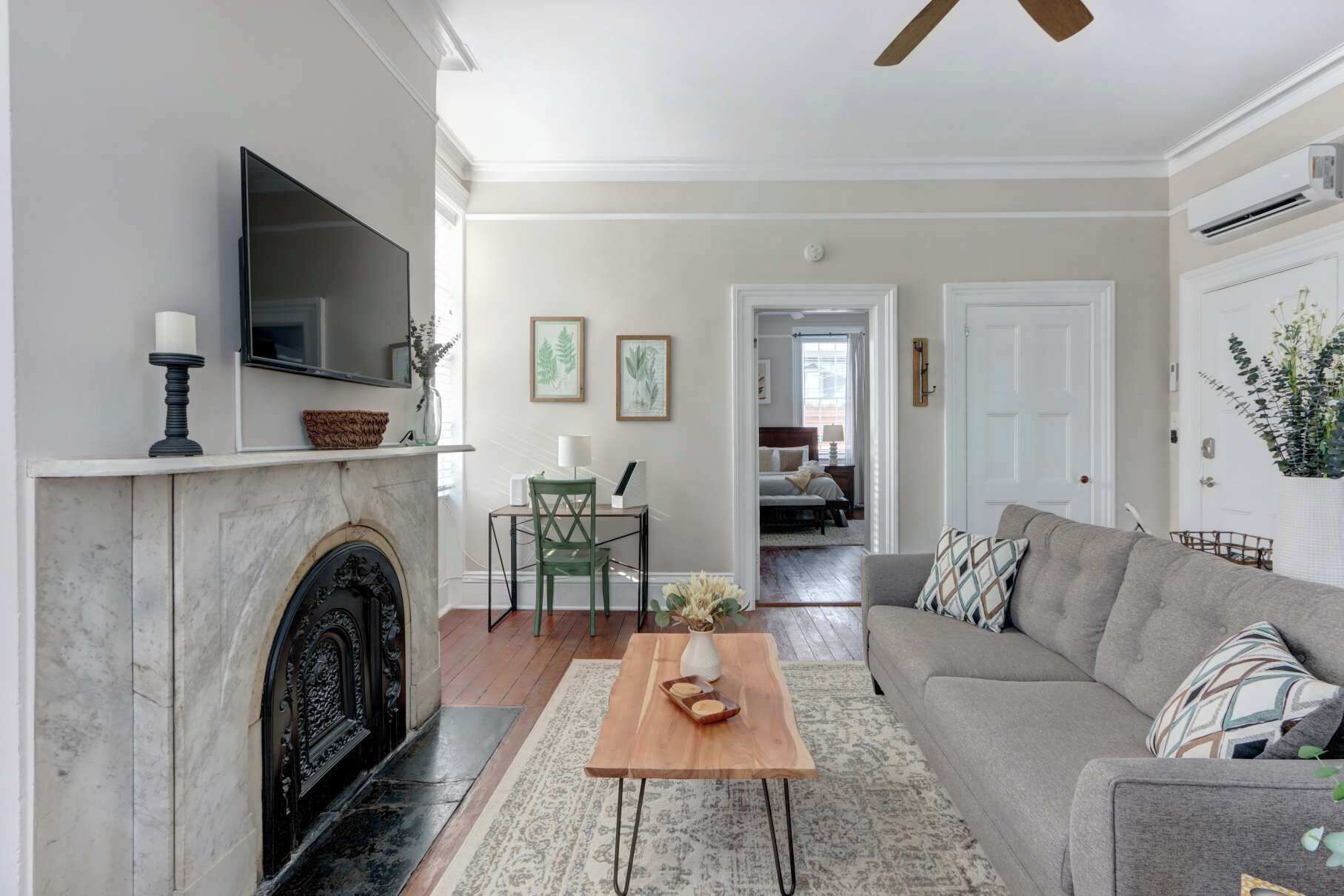 A living room with a fireplace, a sofa, a coffee table, and a television.
