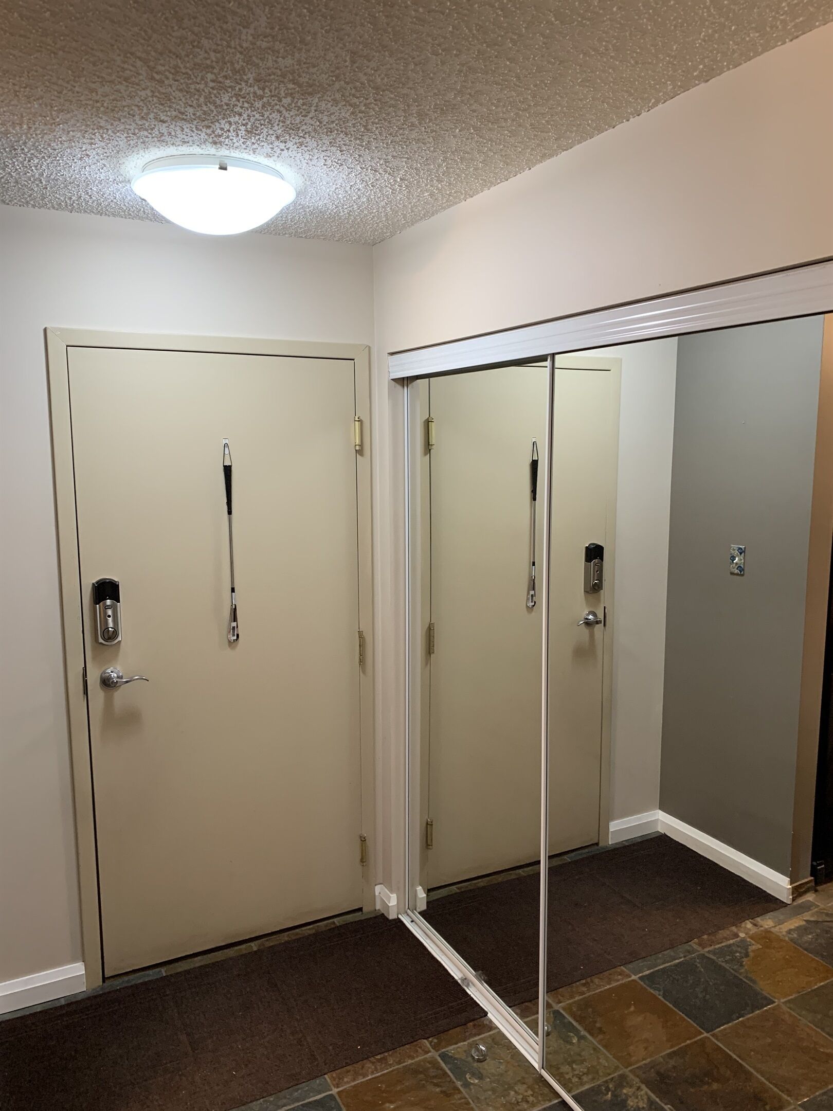 Une pièce dotée de deux portes, dont une avec une serrure à clé et l’autre avec une porte coulissante miroir.