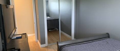 Ein Schlafzimmer mit Bett, Fernseher und Kleiderschrank.