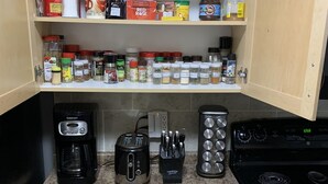 A kitchen with a coffee maker, toaster, knives, and a stove. - Cozy condo, close to Northgate mall and Ring road Top Floor. (REGINA)