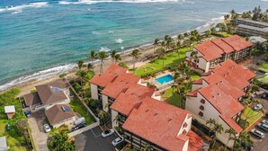 A resort with multiple buildings, a swimming pool, and a beach view. - Kapaa Shore A201 Oceanfront! (Kapaa)