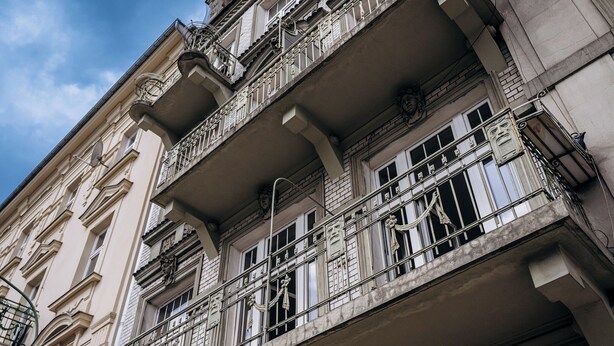 Ein mehrgeschossiges Gebäude mit aufwendigen Balkonen und klassischen architektonischen Details.