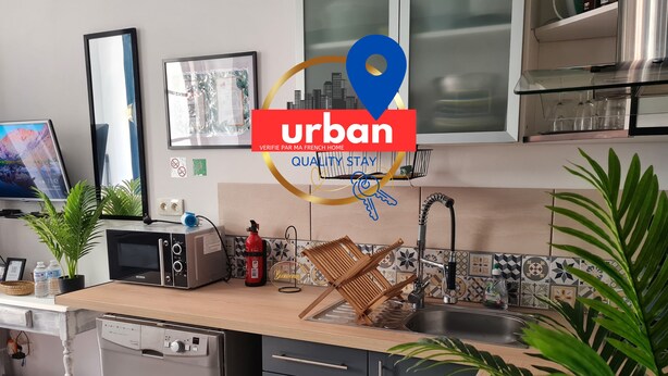 A modern kitchen with a microwave, toaster, and sink. There are plants, a fire extinguisher, and a welcome sign.