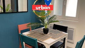 A dining area with a table, chairs, and a potted plant.