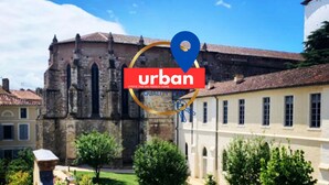 A courtyard with a historic building, a modern building, and a blue location pin indicating an urban area.