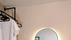 A bedroom with a mirrored wardrobe, a dresser, and a patterned rug. - Hyper-centre de Perpignan : Studio chic à deux pas de tout ! (Perpignan)