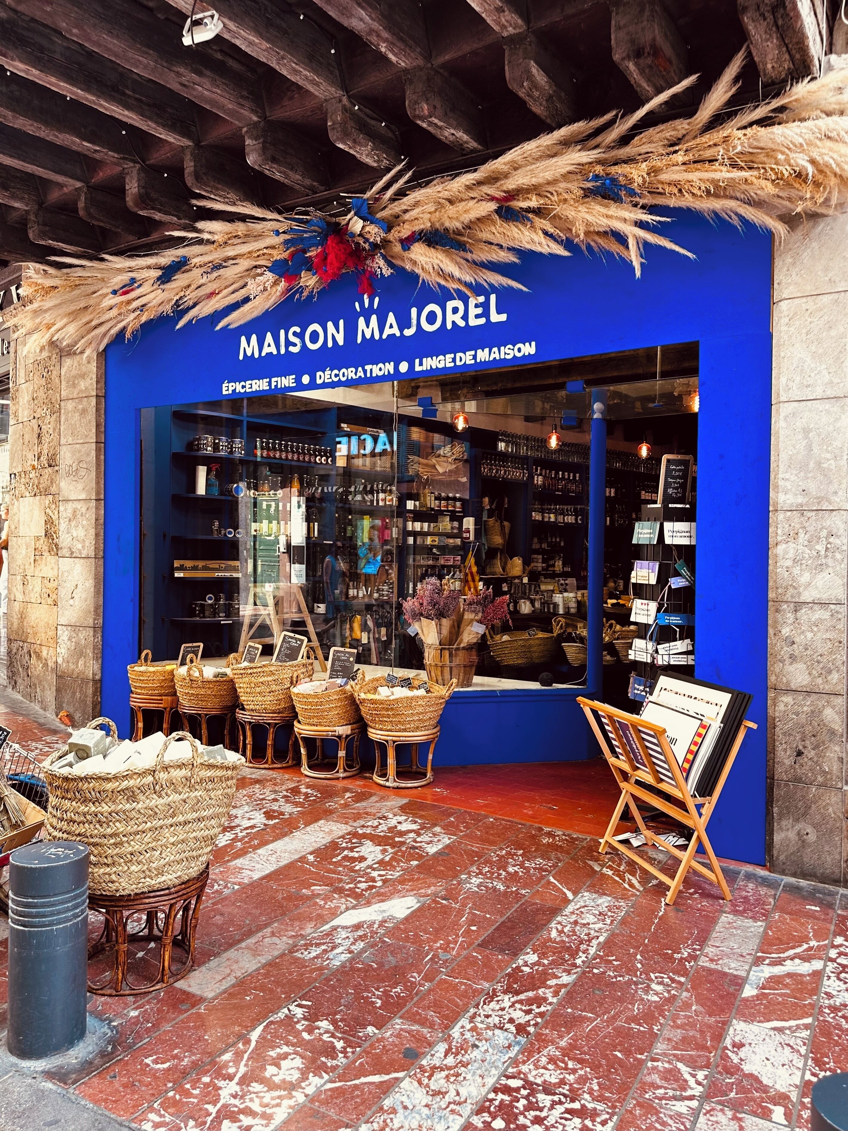 A storefront with a blue facade, wicker baskets, and a display of home decor items.