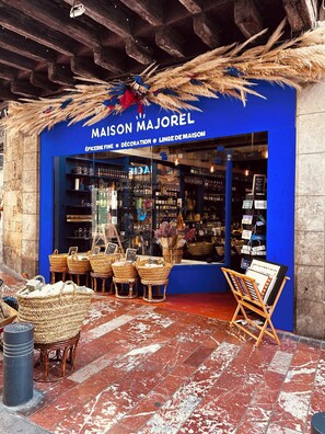 A storefront with a blue facade, wicker baskets, and a display of home decor items. - Hyper-centre de Perpignan : Studio chic à deux pas de tout ! (Perpignan)