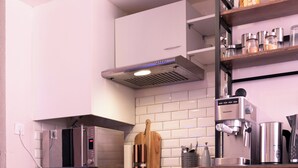 A compact kitchen with a washing machine, a compact refrigerator, a microwave, and a coffee maker. - Hyper-centre de Perpignan : Studio chic à deux pas de tout ! (Perpignan)