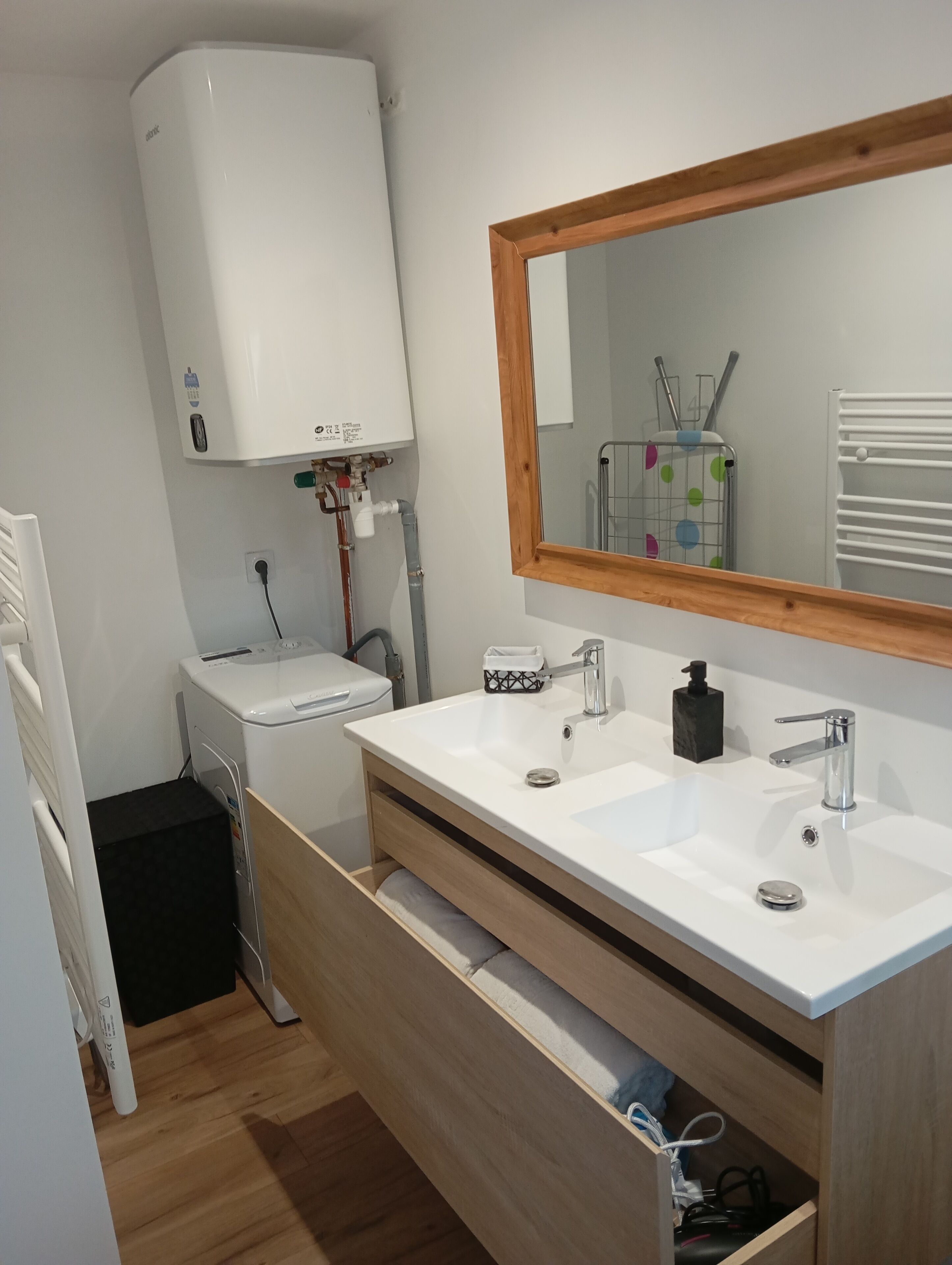 A bathroom with a white sink, a mirror, a toilet, and a white heater.