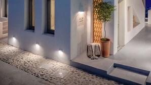 A modern building with a white facade, multiple windows, and a staircase leading to the upper level. - Ico Santorini (Santorini)