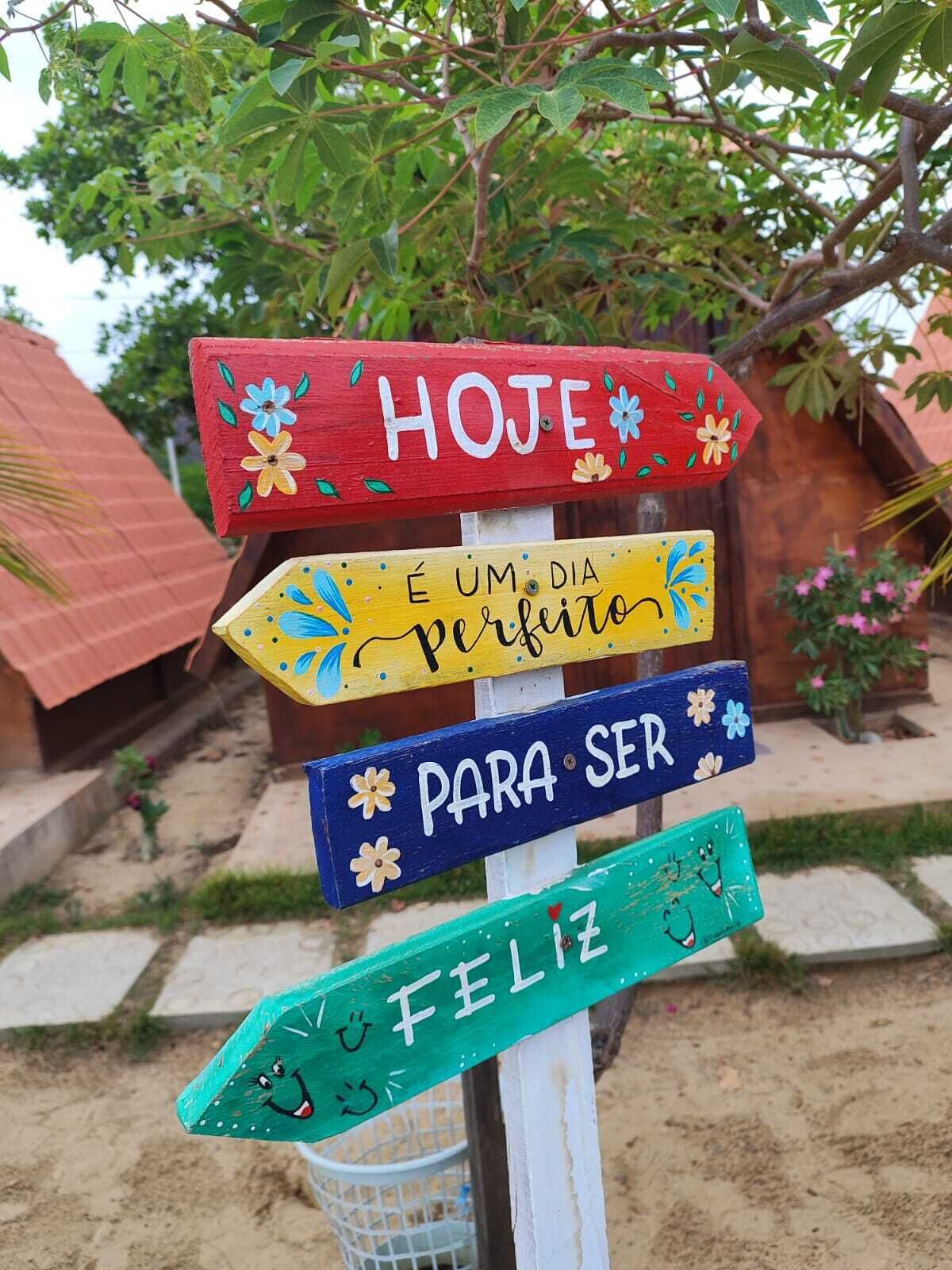 A colorful signpost with various messages in Portuguese.