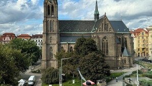 A historic church with a tall clock tower, surrounded by urban buildings and a pedestrian area. - Charming 1-bedroom apartment in enchanting Prague with WiFi (Hlavní mesto Praha)