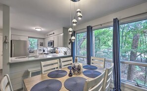 Enjoy meals in the kitchen with a central island, sink, and microwave, and dine in the adjacent area with a table and chairs.