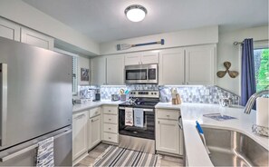Prepare meals in the fully equipped kitchen with a refrigerator, microwave, and stove, and enjoy the natural light from the large window.